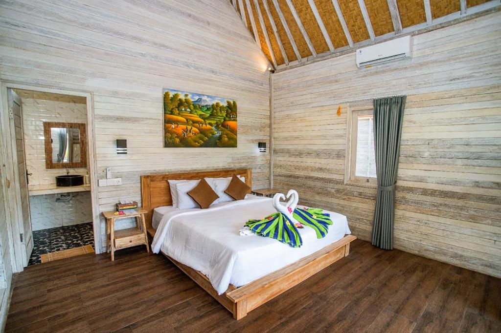 ein Schlafzimmer mit einem Bett in einem Zimmer mit Holzwänden in der Unterkunft Blue Sky Villa Ceningan in Nusa Lembongan