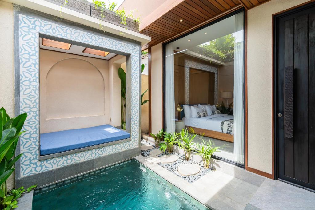 a house with a swimming pool next to a bedroom at Blue Calm Villas Bali in Tumbak Bayuh