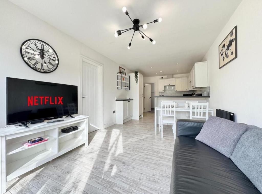 a living room with a couch and a clock on the wall at Doncaster 2-Beds Sleeps 4 with Parking in Doncaster