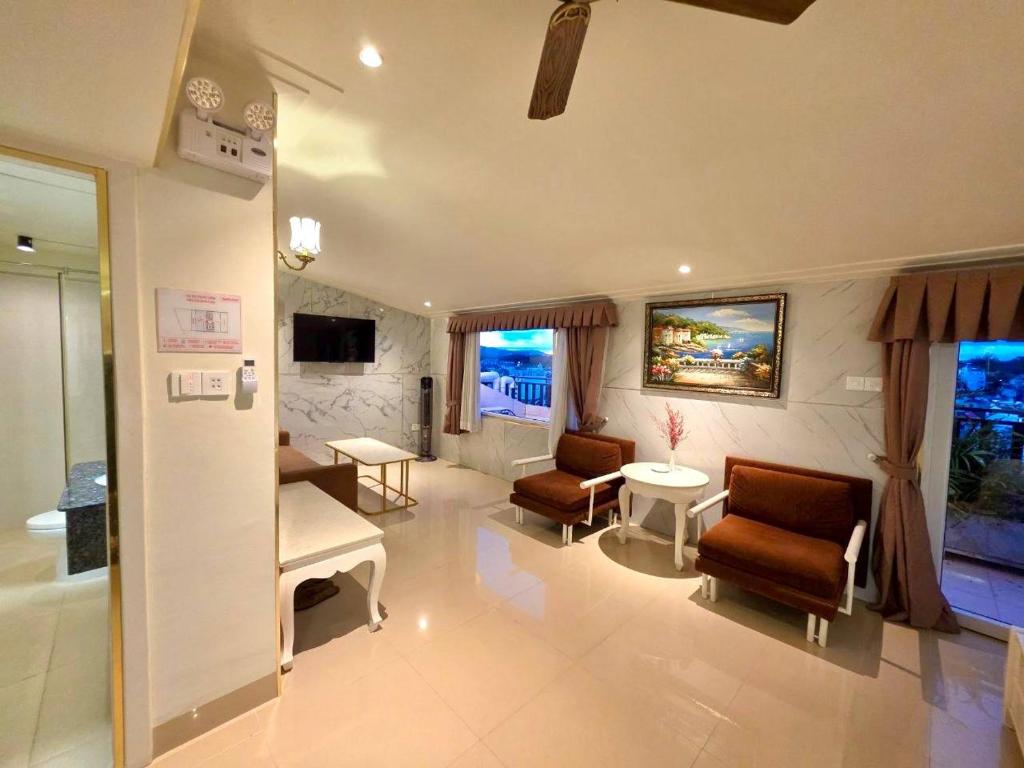 a living room with chairs and a couch and a table at Tulip Hotel 3 in Da Lat