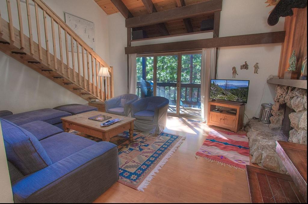 a living room with a blue couch and a tv at Alpine Getaway home in Tahoe City