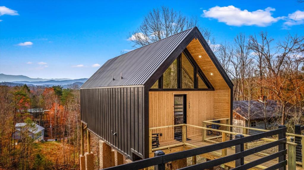 une cabane en bois avec un toit en métal dans l'établissement The Flame Azalea - Luxury Treehouse - Hot Tub, Wi-Fi, Soaring Views, 10 Min to PF - Perfect for Couples!, à Sevierville