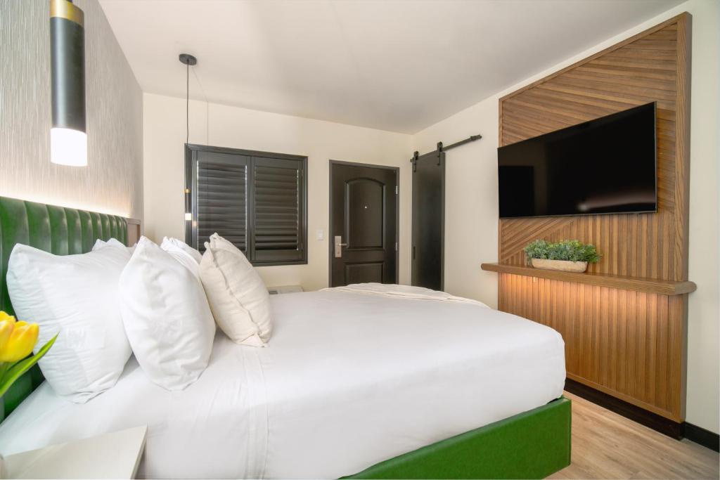 ロサンゼルスにあるLYFE INN & SUITES by AGA- North Hollywood Universal Studiosの白いベッド(白い枕付)、薄型テレビが備わります。