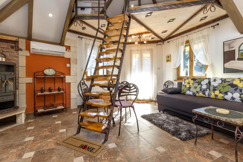 een woonkamer met een bank en een spiraalladder bij Apartment Romansa in Split