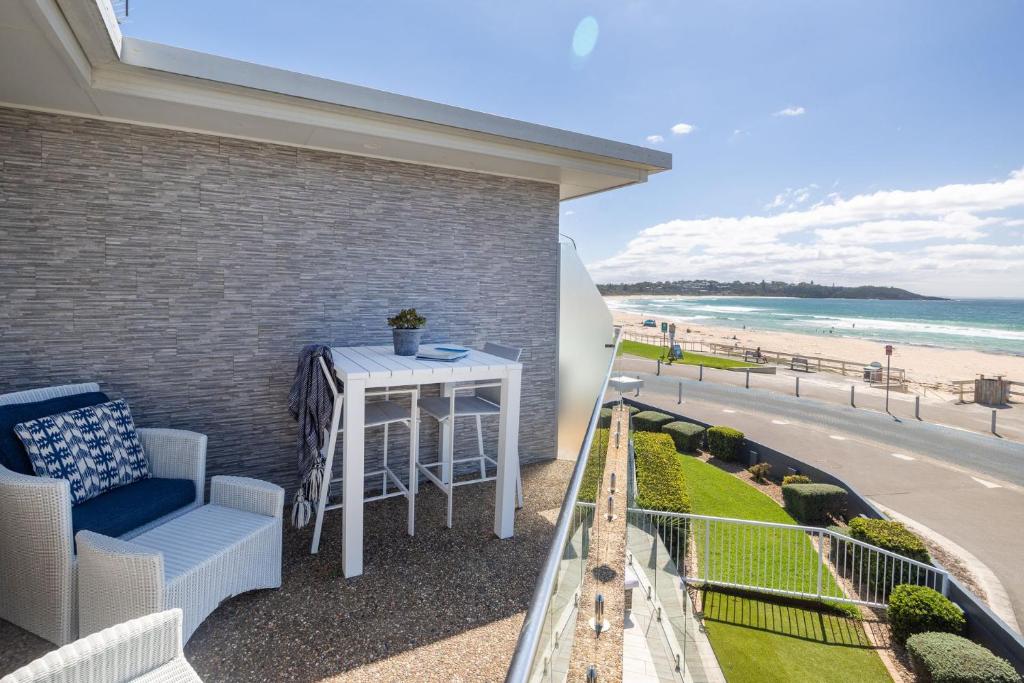 Un balcón con mesa y vista a la playa. en Mariners 5, en Mollymook