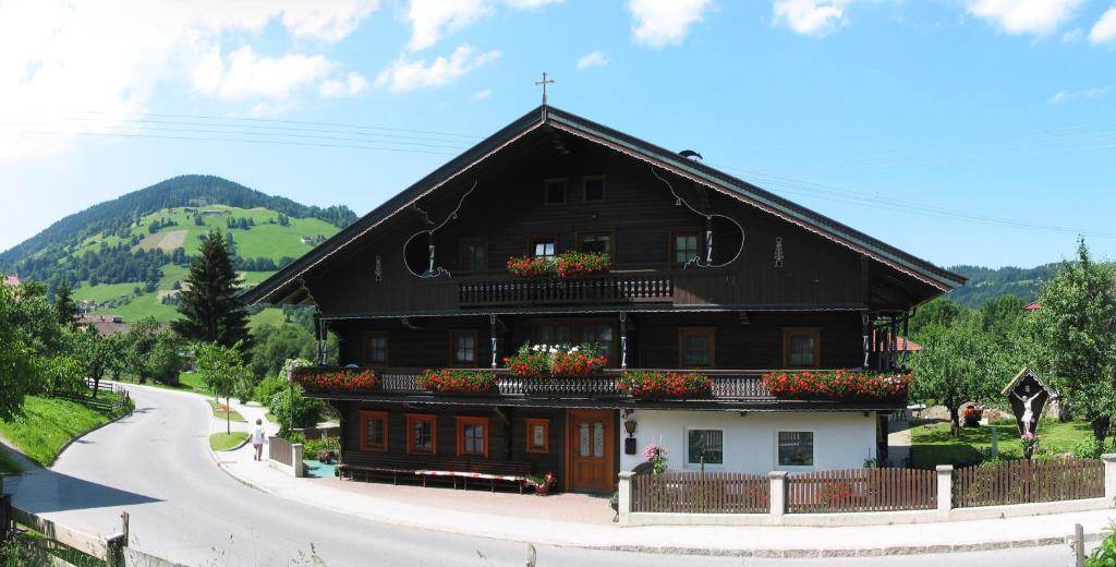 a black and white building with flowers on the balcony at Haus Seiwald in Niederau