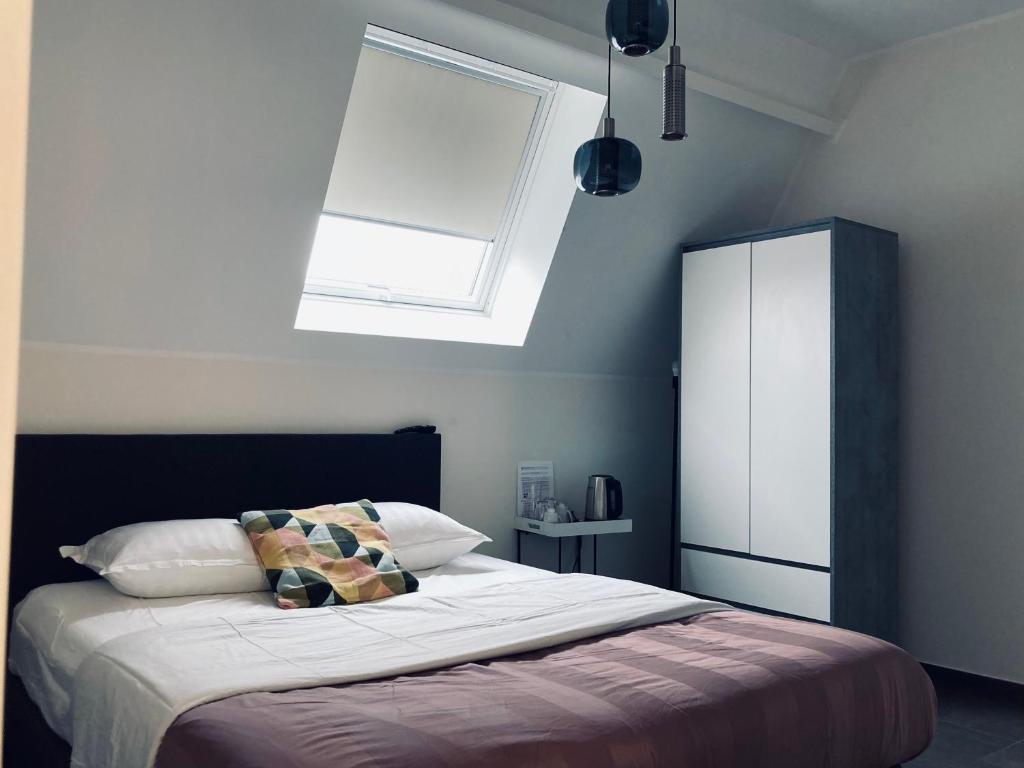 a bedroom with a large bed with a skylight at Côté Grange in Tournai