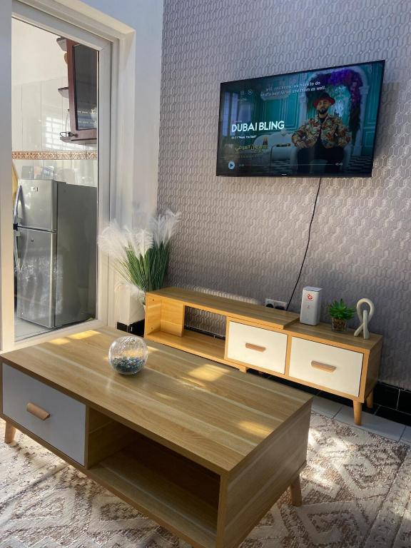 a living room with a tv and a coffee table at Nadi Homes in Dar es Salaam