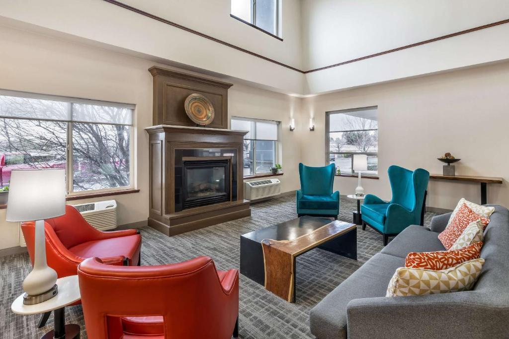 sala de estar con sillas coloridas y chimenea en Comfort Suites Redmond Airport, en Redmond