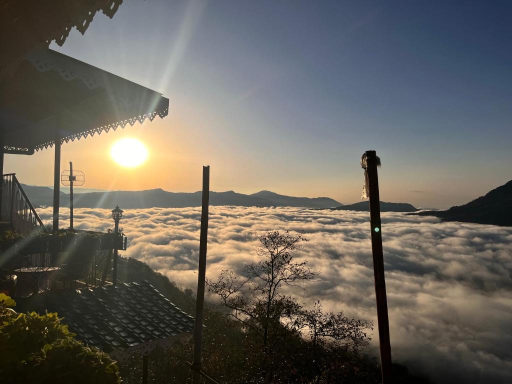 una vista del sole che sorge sopra le nuvole di Sky View Homestay a Pelling