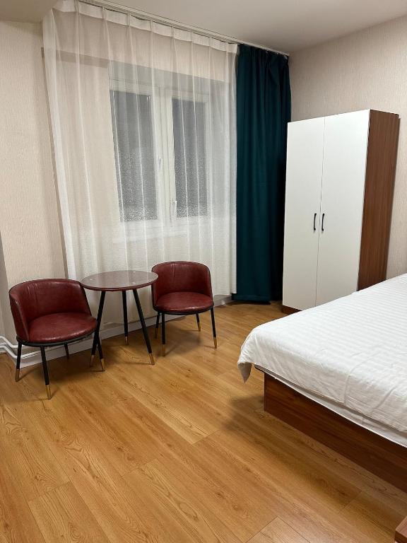 a bedroom with a bed and a table and chairs at Comfy apartment in Central UB in Ulaanbaatar