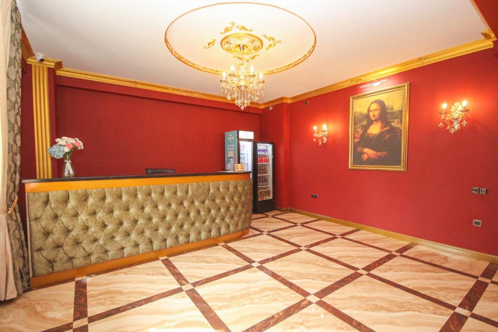 a hotel lobby with red walls and a chandelier at Da Vinci Hotel in Almaty