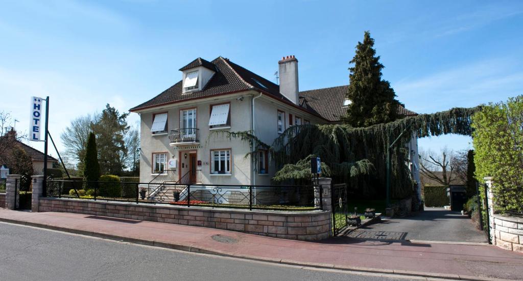 a white house with a fence on a street at Belvedere Montargis Amilly in Amilly