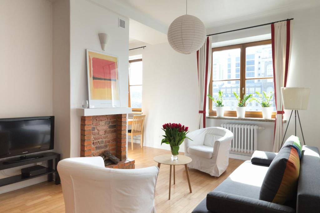 un soggiorno con divano, sedie e TV di Apartament One by Your Freedom a Varsavia