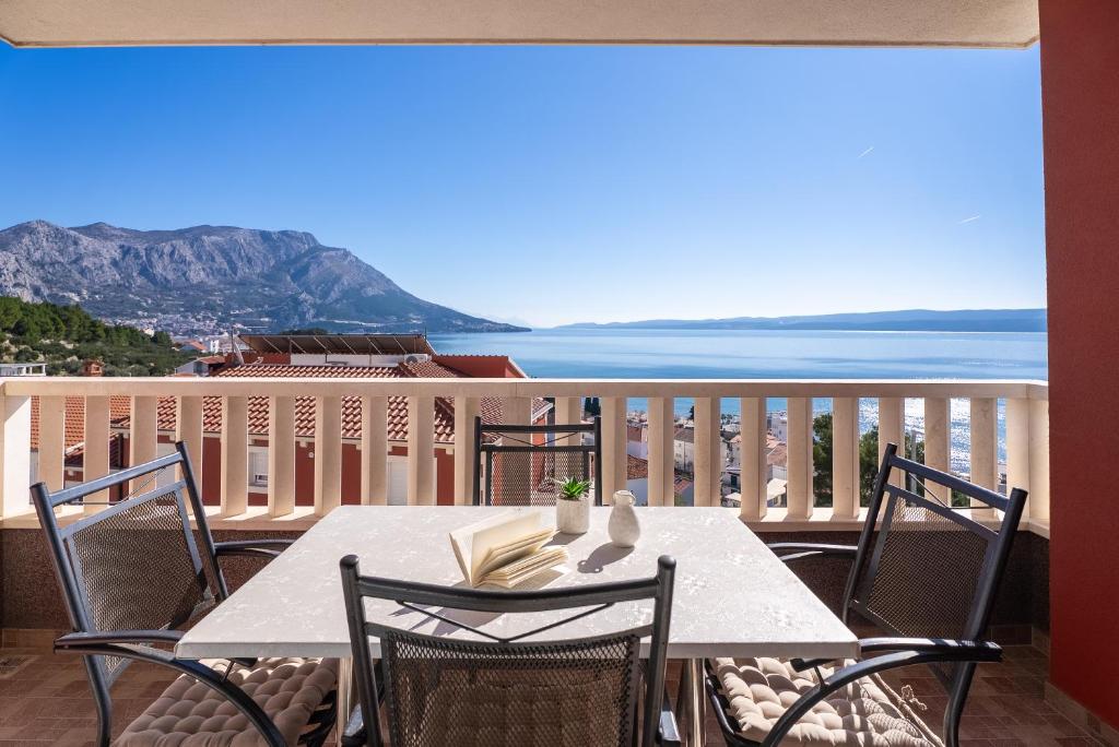 een tafel op een balkon met uitzicht op de oceaan bij Apartments Bakota in Omiš