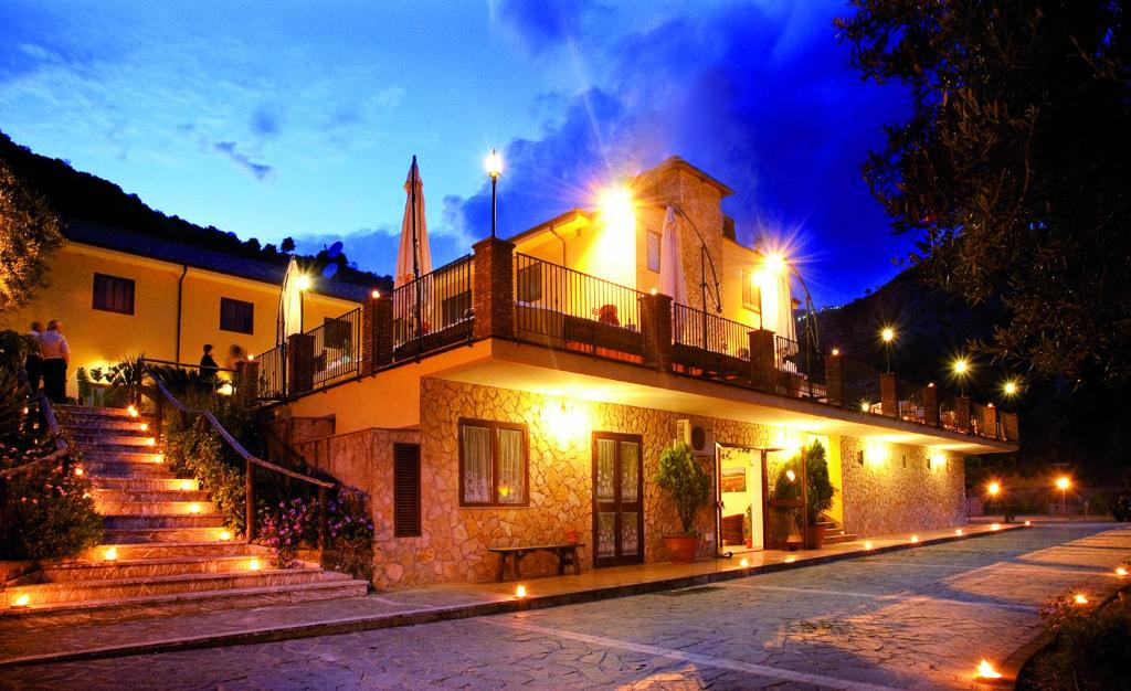 budynek z balkonem i schodami w nocy w obiekcie Agriturismo Villa Orchidea w mieście Ali Terme