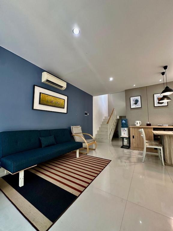 a living room with a couch and a blue wall at City side retreat Adelaide house in Tambakmanukan