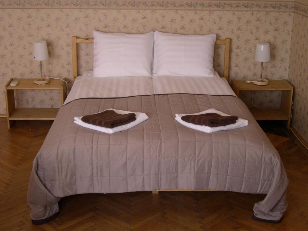 a large bed with two nightstands and two lamps at 4YOU Citycenter Apartments in Budapest
