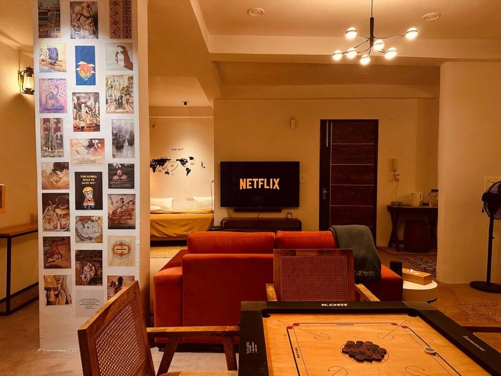 a living room with a couch and a tv at Leafyinn Elysian Escape Condo in New Delhi