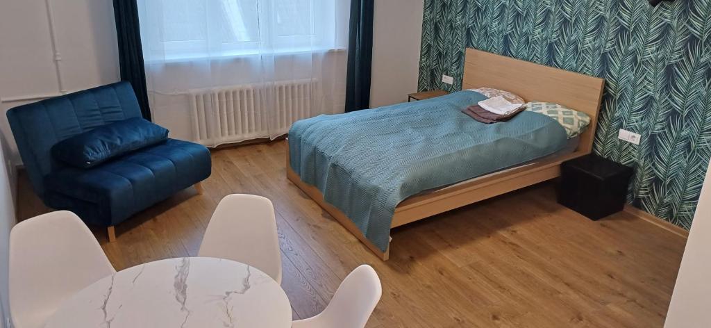 une chambre avec un lit, une chaise et une table dans l'établissement Center & homely Apartment, à Klaipėda