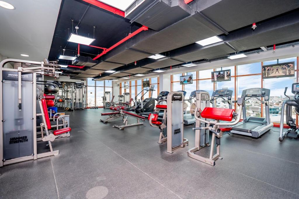 einen Fitnessraum mit mehreren Laufbändern und Heimtrainern in der Unterkunft Beautiful Palm Studio with a Wow View in Dubai