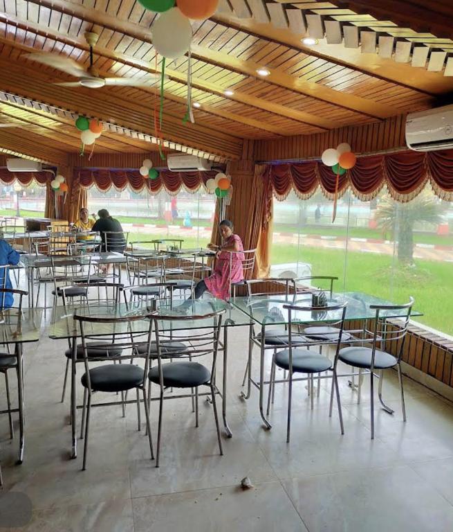 a dining room with tables and chairs and people at Green Balley Resort On Beach in Mandarmoni