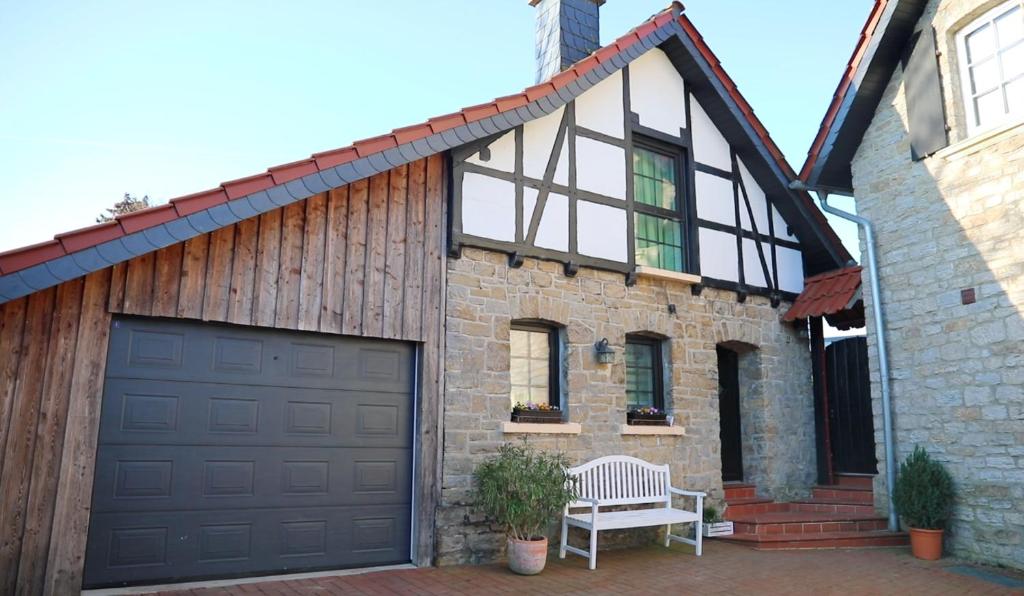 a garage door on a brick house with a bench at Haus Norderteich in Horn-Bad Meinberg