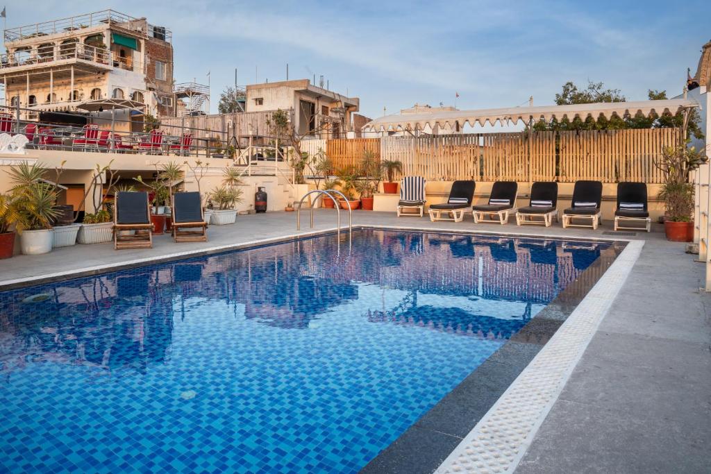 een zwembad met stoelen op een gebouw bij Udaigarh - Udaipur in Udaipur