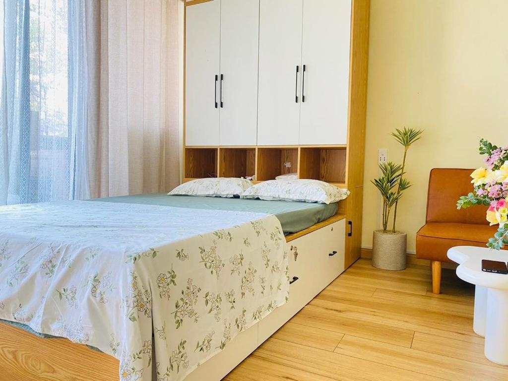 a bedroom with a bed with white cabinets and a chair at KimHouse in Ho Chi Minh City