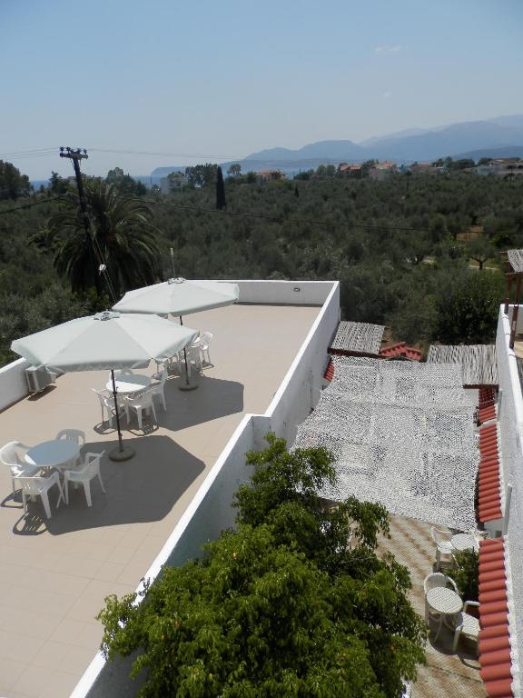 a patio with tables and umbrellas on a building at Aeolos Hotel Apartments in Gythio