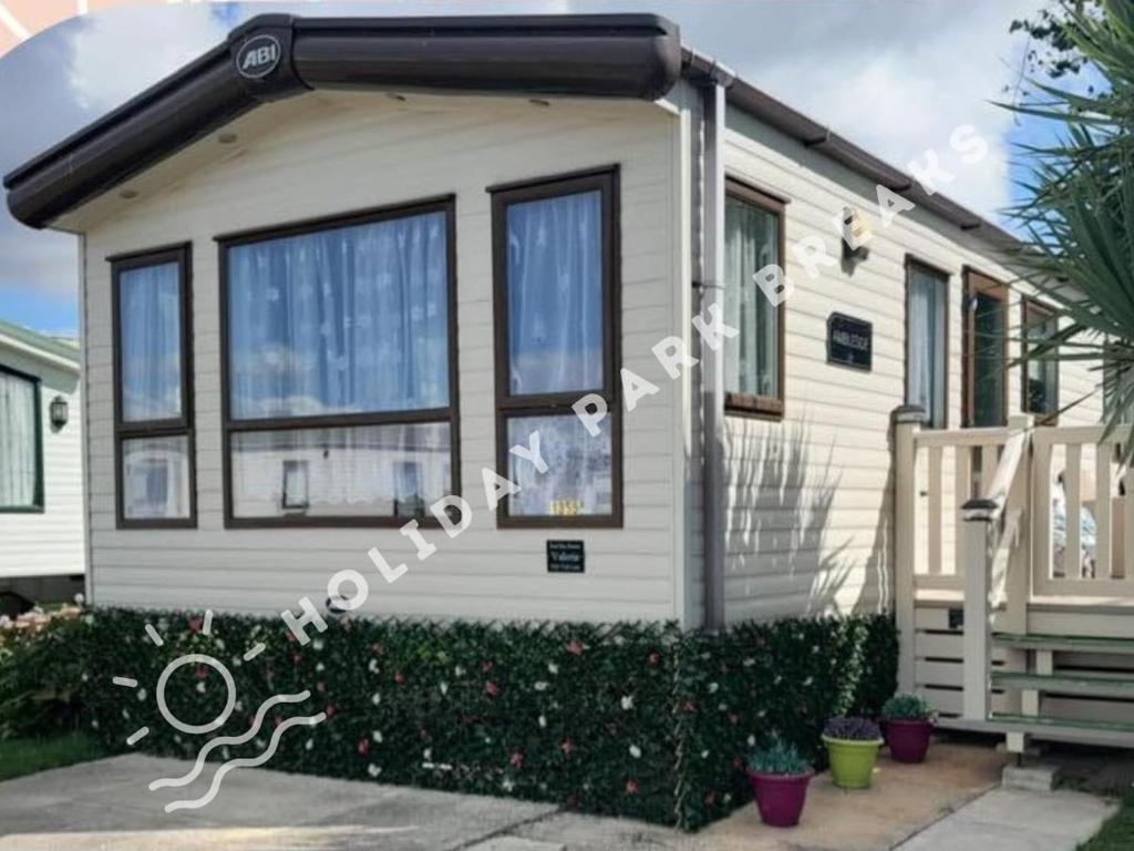 a tiny house with a porch and a staircase at Valeria - Gold 3 bedroom with Garden and Parking - Seal Bay in Selsey