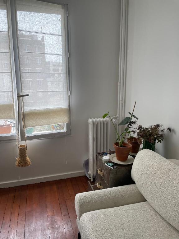 un salon avec un canapé et une fenêtre dans l'établissement Appartement, à Aubervilliers