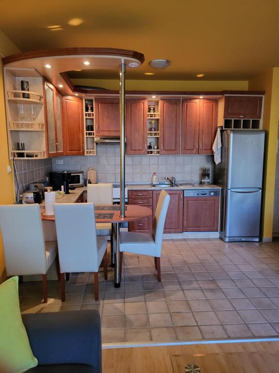 kuchnia ze stołem, krzesłami i lodówką w obiekcie Kiss-Füredi Apartman Szeged w Segedynie