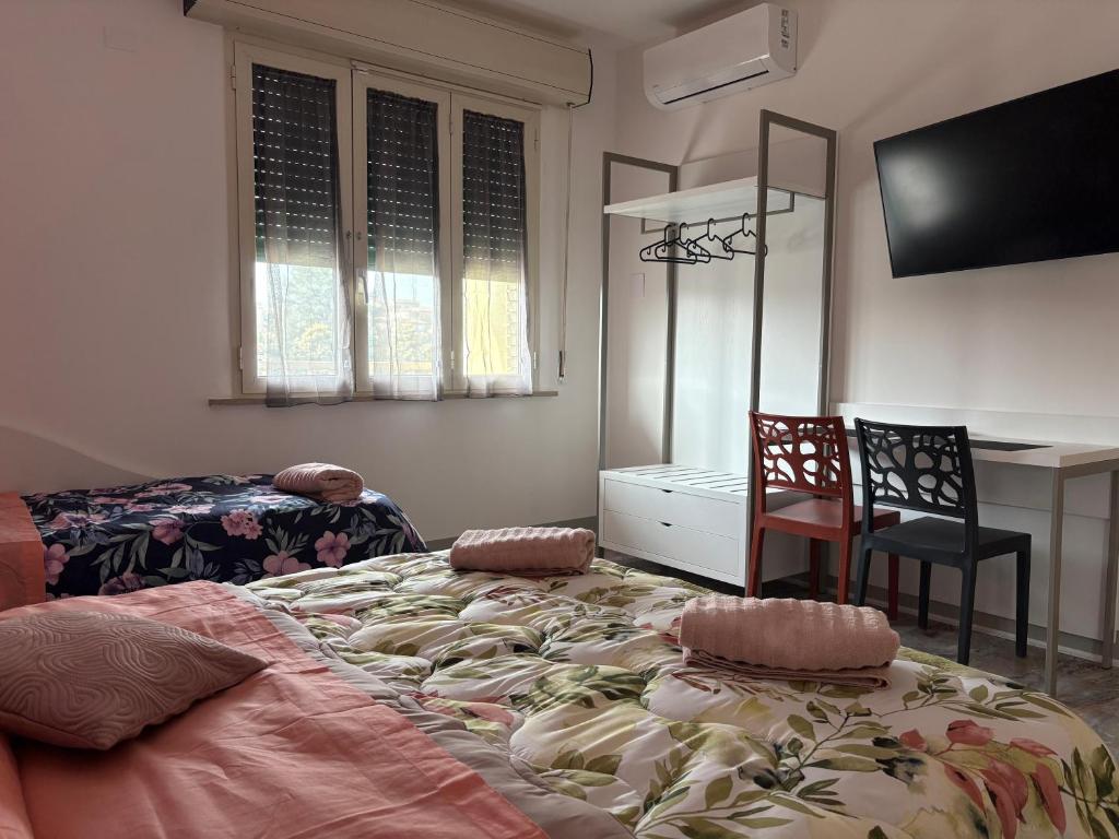 a bedroom with a large bed with a chair and a desk at Affittacamere Jesi in Iesi