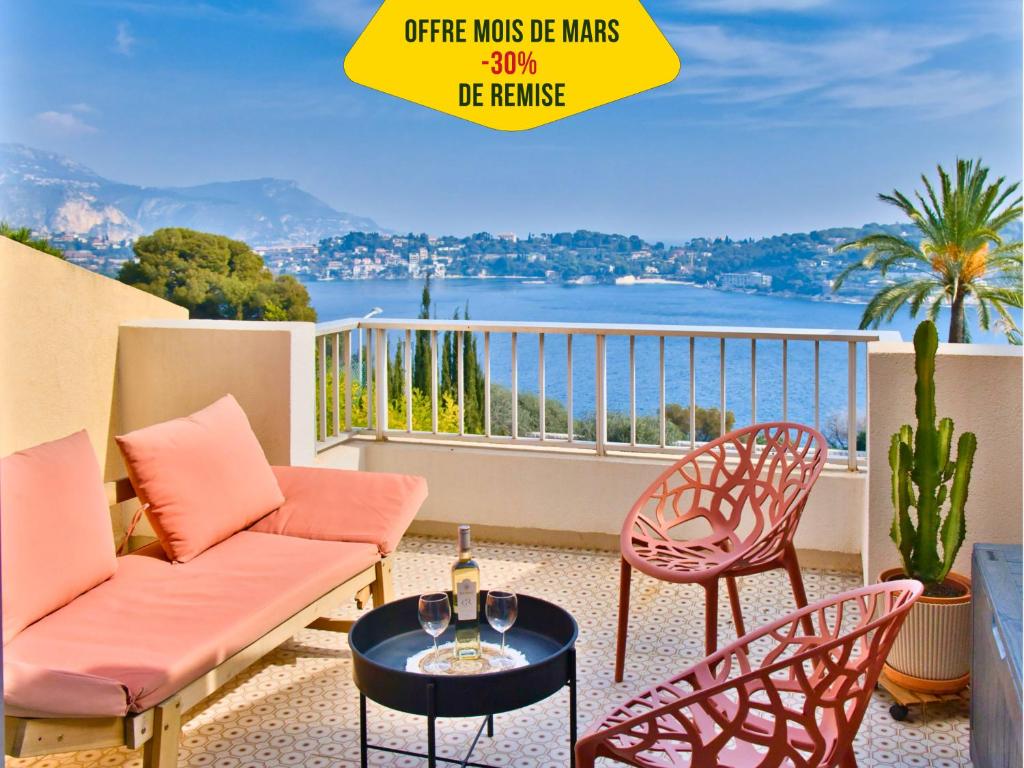 d'un balcon avec un canapé et des chaises offrant une vue sur l'eau. dans l'établissement Magnifique Appartement avec Vue Mer Panoramique, à Nice