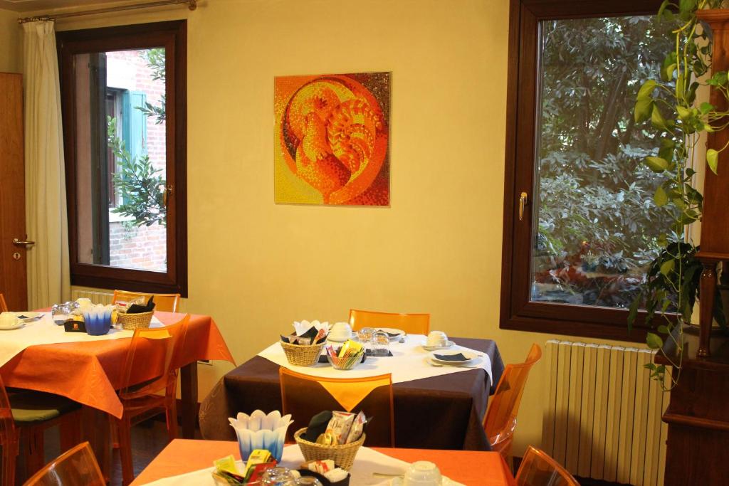 comedor con 2 mesas y 2 ventanas en Domus Orsoni, en Venecia