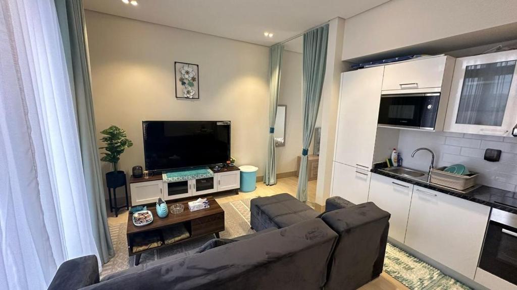 a living room with a couch and a flat screen tv at salalah ,hawana ,RV01-101 in Salalah