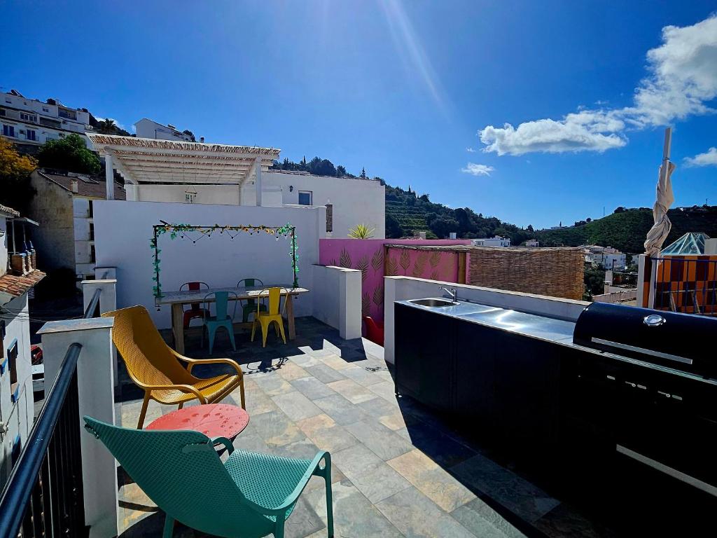 a patio with chairs and a table on a balcony at Olé Toledo in Cómpeta