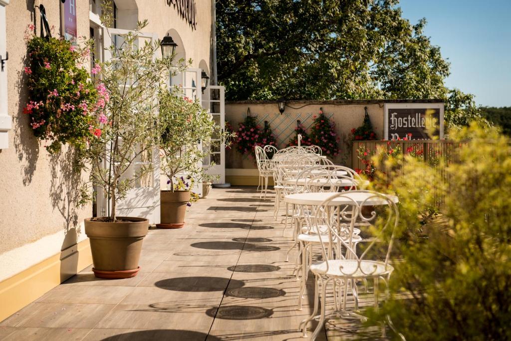 a row of white chairs and tables on a patio at Hostellerie Bellevue in Rocamadour