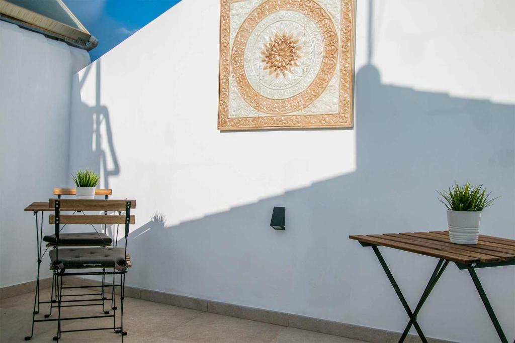 a table and a chair next to a wall with a picture at APARTAMENTOS CARMEN in Maro