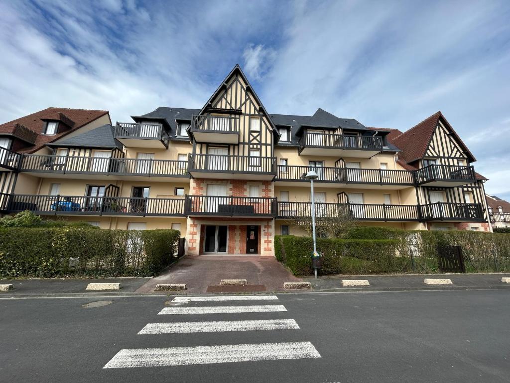 un grand bâtiment avec des balcons sur le côté d'une rue dans l'établissement 2 Pièces secteur Thalasso et Mer, à Cabourg