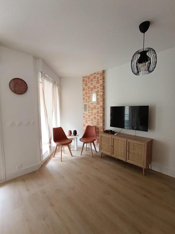 - un salon avec une télévision et deux chaises dans l'établissement Studio coin nuit Riviera Plage, à Roquebrune-Cap-Martin