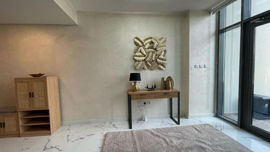 ein Raum mit einem Tisch und einem Bild an der Wand in der Unterkunft Luxury Canal View Apartment Near Yas Island DABAS1 in Abu Dhabi