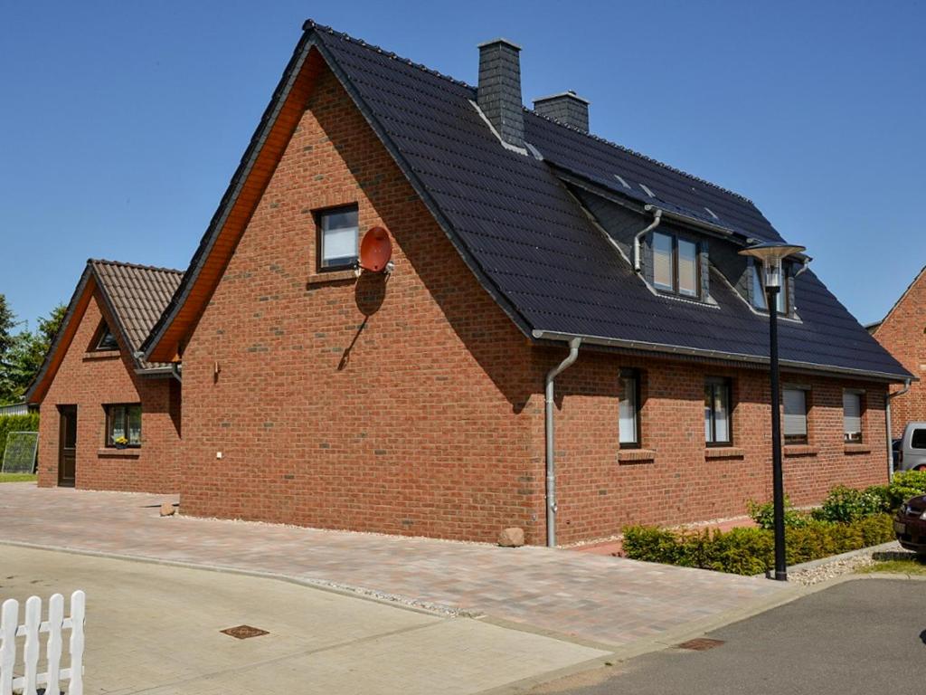 una casa de ladrillo rojo con techo negro en Haus der Gemütlichkeit, en Ribnitz-Damgarten