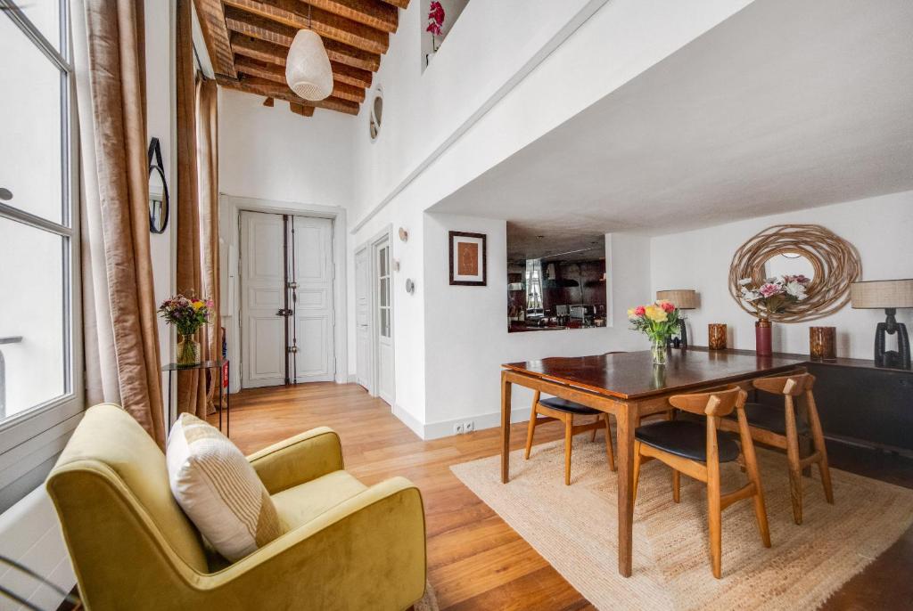 un salon avec une table et des chaises de salle à manger dans l'établissement Les appartements de l'atelier Paris 3, à Paris