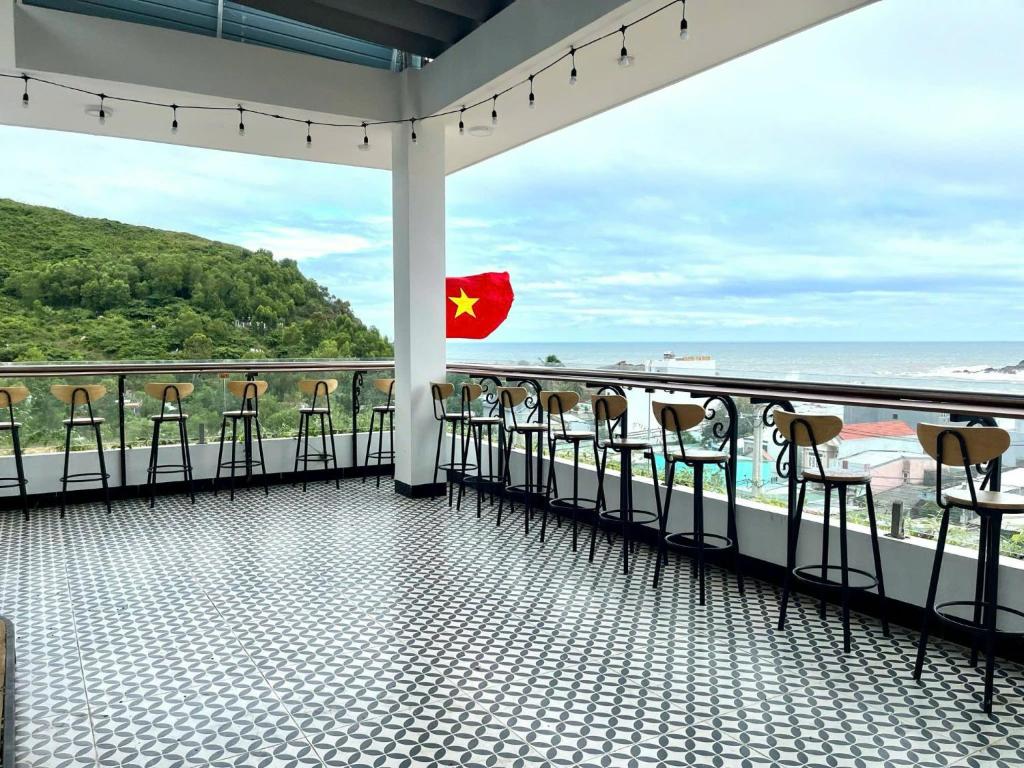 a balcony with chairs and a view of the ocean at SÓNG Coffee & Homestay in Quy Nhon