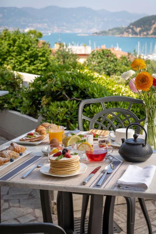 a table with food and drinks on it with a view of the ocean at Doria Park Hotel in Lerici
