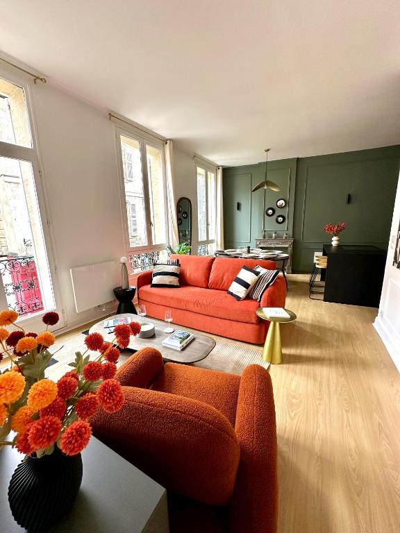 un salon avec un canapé orange et une table dans l'établissement Cœur des Calades - Élégance et Luxe Intemporel, à Avignon