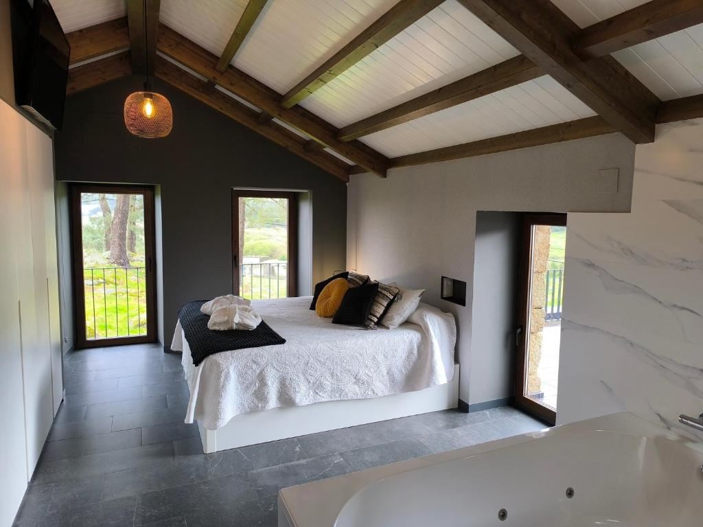 sypialnia z łóżkiem i wanną w obiekcie A Casa de Costa w mieście Laxe