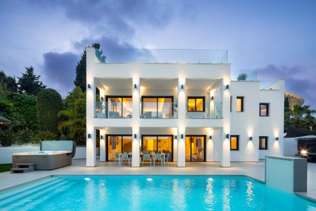 a white house with a swimming pool in front of it at Villa Angelique, 5 BDR with Heated Private Pool in Puerto Banus in Marbella
